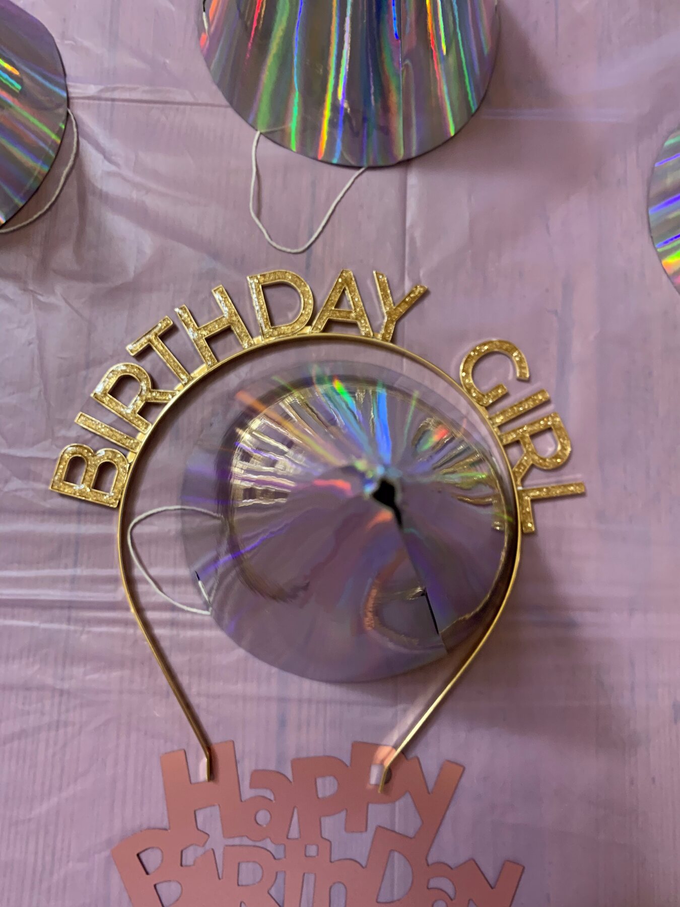 Čelenka Birthday Girl a holografické balónky na fialovém ubruse — detail stylingu oslavy